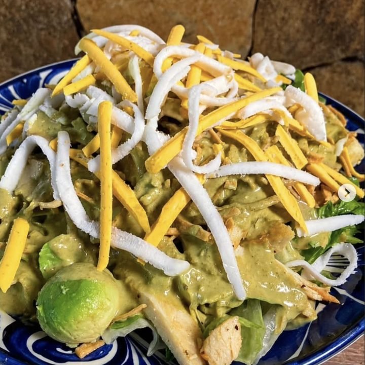 Ensalada fresca con pollo y queso en plato de talavera