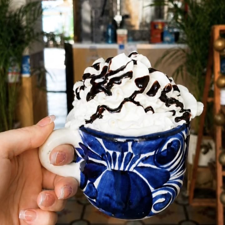 Chocolate caliente con crema batida en taza de talavera