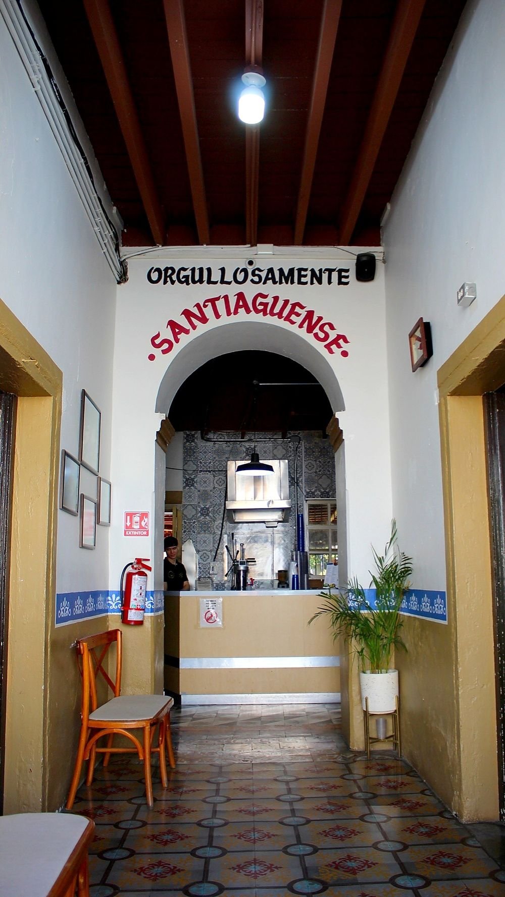 Pasillo de La Churrería Santiago con piso de mosaico de talavera y el mural pintado en la pared que dice «Orgullosamente Santiaguense»